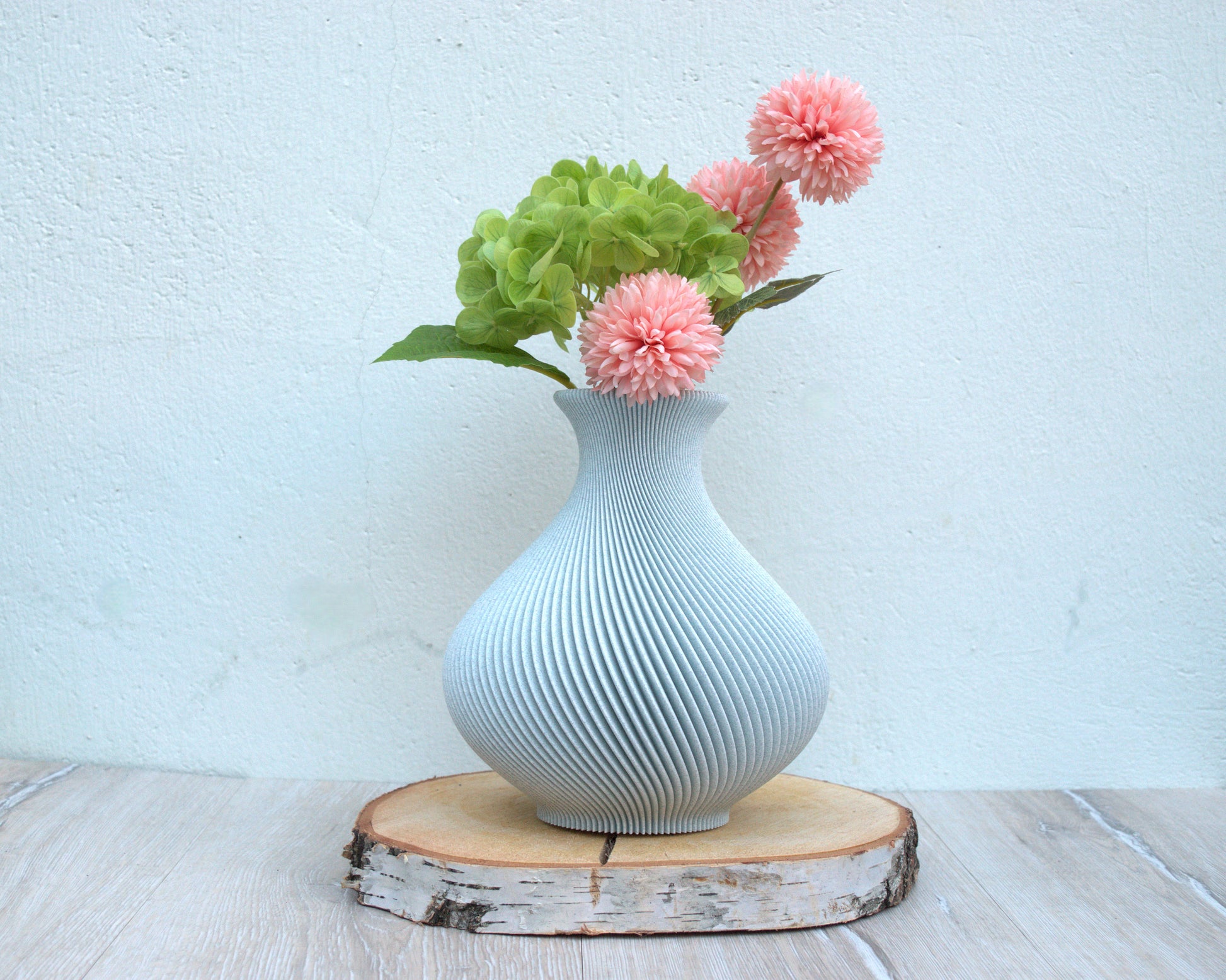 Dekorative Vase mit spiralförmigem Design. Die Vase verfügt über einen wasserdichten Inneneinsatz und eignet sich für Schnittblumen und Trockenblumen.

Farbe Waldgrüner (hellgrau-grün) Marmor 