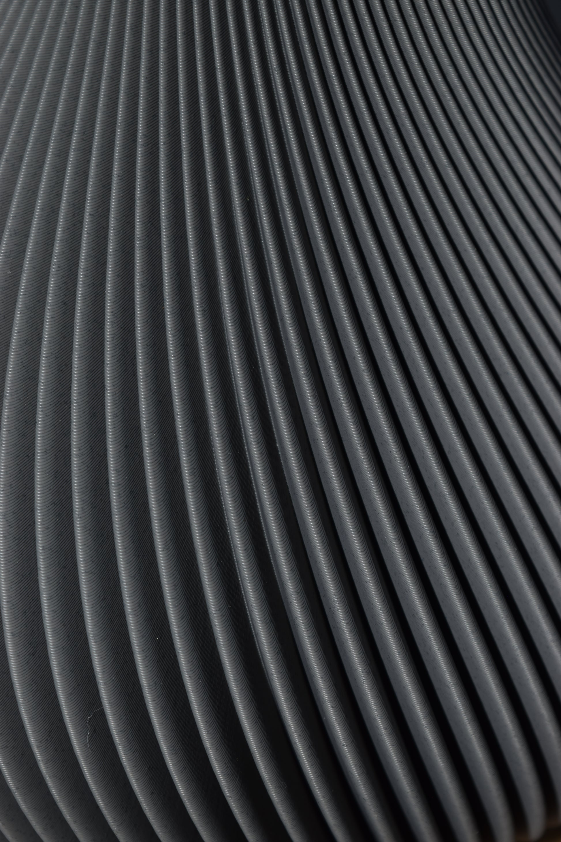 Detailaufnahme einer fein geriffelten 3d-Druck-Oberfläche in aschbeton (grau) Optik.
Die gleichmäßig verlaufenden Bögen verleihen dem Material eine elegante und moderne Anmutung.