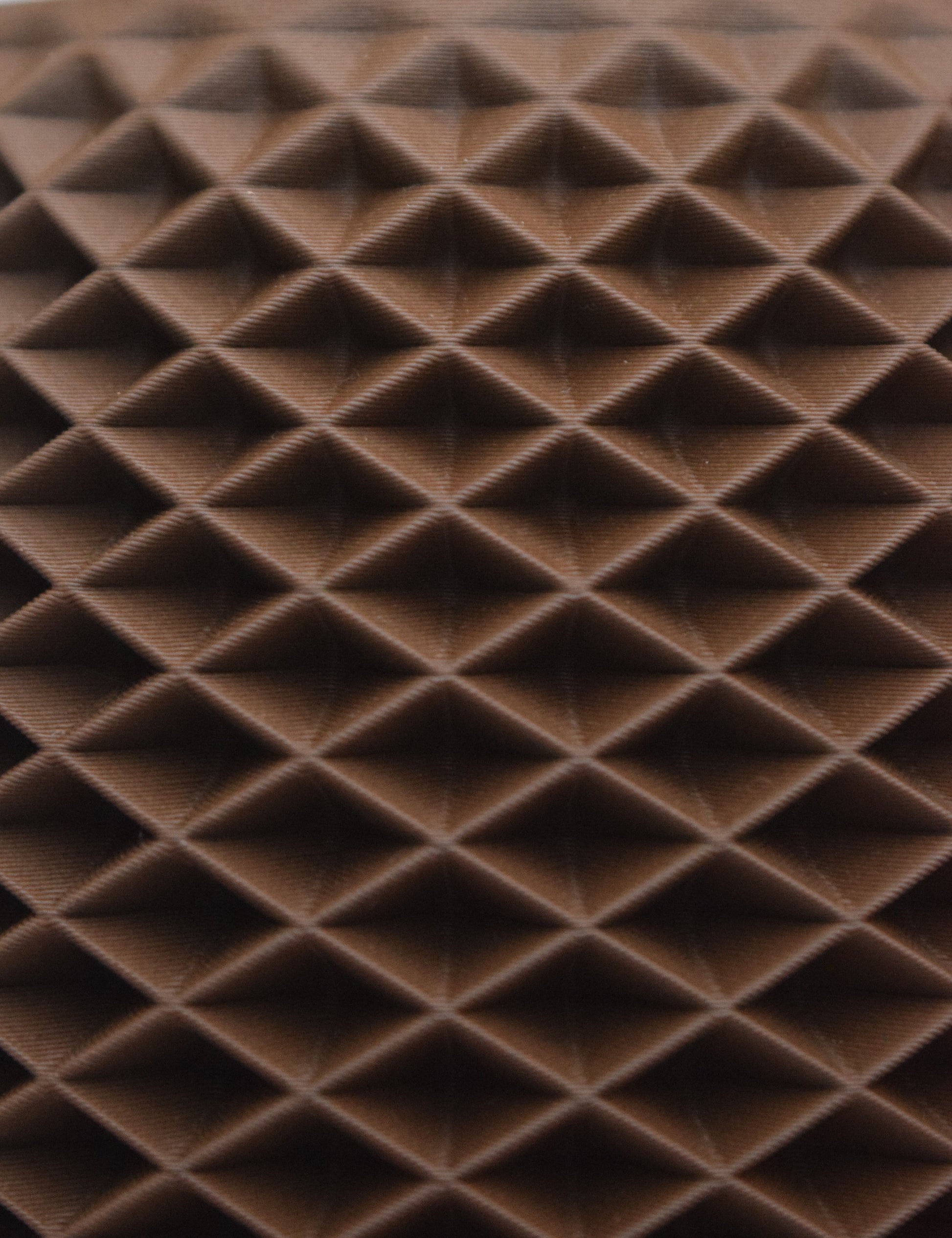 Nahaufnahme einer 3D-gedruckten Oberfläche die an eine Pyramide oder Diamanten erinnert. das geometrische Muster erzeugt eine dreidimensionale Struktur mit Licht und Schatteneffekte.

Farbe Braun (schwarze Walnuss)