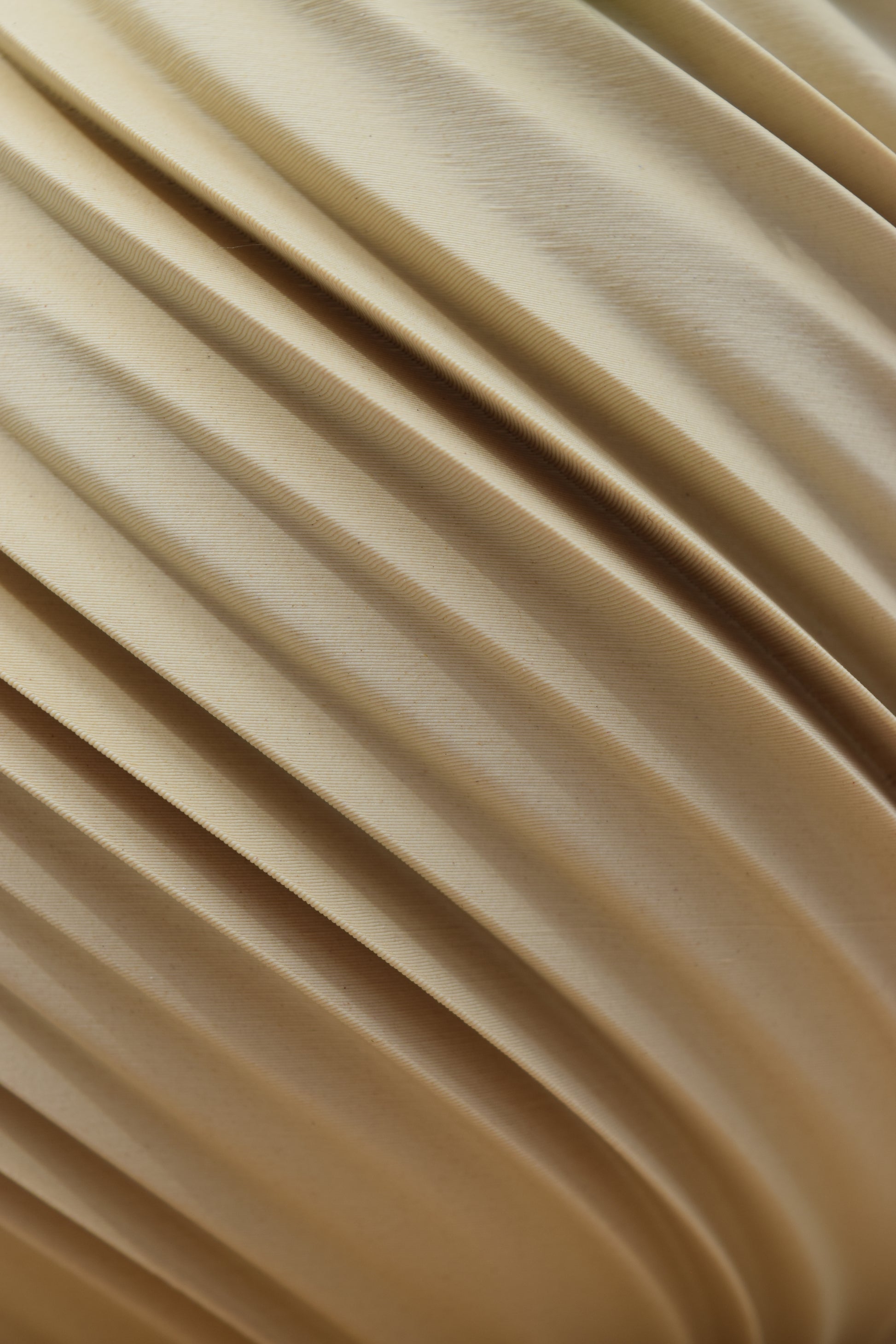 Detailaufnahme einer 3D-gedruckten Oberfläche in einem neutralem beige (Weißeiche). Die geschwungenen und spiralförmigen  Rillen verlaufen diagonal über das Bild und erzeugen eine fließende, organische Struktur.